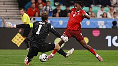 Slovinský branká Jan Oblak se staví do cesty Johanu Manzambimu ze výcarska.