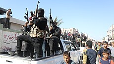 lenové palestinského teroristického hnutí Hamás doprovázejí vozidla erveného...