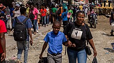 Haiané se proplétají ulicemi Port-au-Prince, kde lidé bez domova protestují...