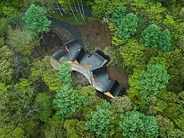 Chaty propojuje klikatá, socha�sky tvarovaná �erná st�echa a d�ev�ná terasa,...