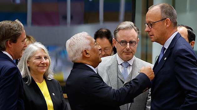 N�meck� kancl�� Friedrich Merz se za dohledu belgick�ho premi�ra Barta De Wevera zdrav� s p�edsedou Evropsk� rady Ant�niem Costou. (23. ��jna 2025)