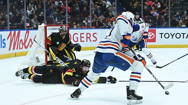 Filip Hronek se sna�� vle�e zabr�nit p�ihr�vce p�es brankovi�t�.