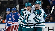 Will Smith (vlevo) a Macklin Celebrini ze San Jose se radují z gólu v utkání...