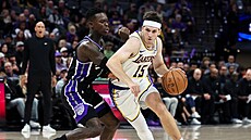 Austin Reaves se snaí projít do koe pes Dennise Schrödera.