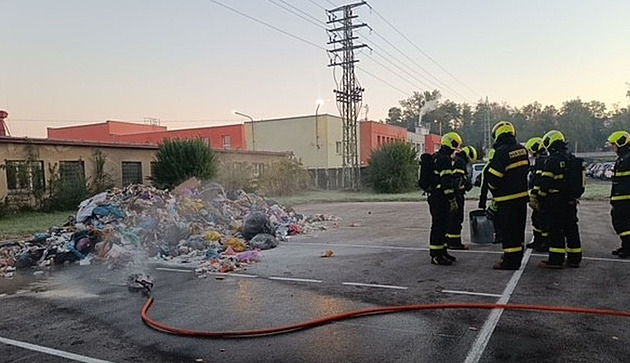 Karvin�tí hasi�i u odpadu vysypaného z popelá�ského vozu, kde za�ala ho�et...