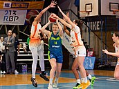 Emese Hofová z USK Praha pihrává v obklíení hráek Basketu Ostrava.