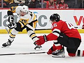 Útoník Blake Lizotte z Pittsburghu stílí okolo Coltona Whitea z New Jersey.