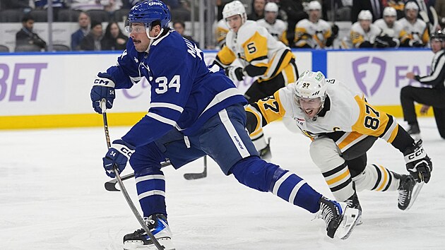 Auston Matthews z Toronta napahuje ke stele, brn ho Sidney Crosby z Pittsburghu.