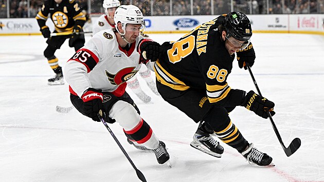 Ottawsk� obr�nce Jake Sanderson se sna�� dostat pod tlak �to�n�ka Davida Pastr��ka z Bostonu (88).