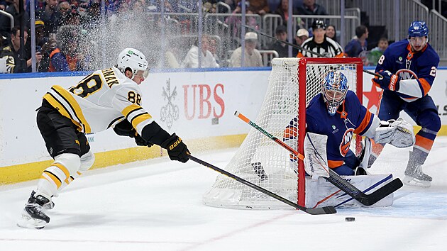 David Pastrk z Bostonu (vlevo) manvruje ped brankou New Yorku Islanders.