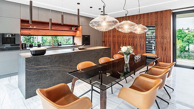 V kuchysk sti jsou k nepehldnut vysok skn a obloen, na kter byla pouita palisandrov dha. Ostrvek m pracovn plochy a opltn z odolnch keramickch panel Dekton