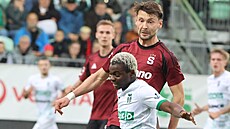 Emmanuel Ayaosi z Karviné si hlídá mí ped sparanem Kasperem Kairinenem.