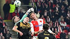 Slávistický obránce Tomá Vlek hlavou pekonává ostravského brankáe Dominika...