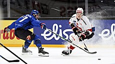 �eský obránce Filip Pyrochta brání rozjetého �výcarského úto�níka Simona Knaka.