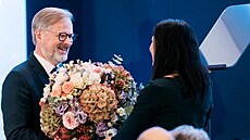 Premiér Petr Fiala p�edává kytici lou�ící se Markét� Pekarové Adamové