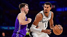 Victor Wembanyama (1) ze San Antonio Spurs se tla�í ke ko�i Los Angeles Lakers,...