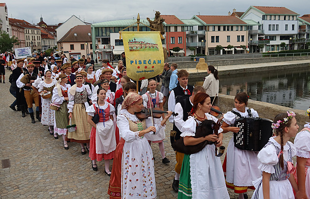 lenov souboru Psean prochzej po Kamennm most v Psku. Prvod soubor je soust mezinrodnho folklornho festivalu.