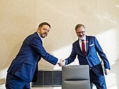 Premiér Petr Fiala a ministr vnitra Vít Rakuan  se zdraví ped schzi vlády v...
