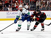 Filip Hronek v akci proti Carolin, stíhá ho Jordan Martinook.