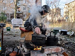Obyvatel Kos�antynivky p�ipravuje jídlo nad ohn�m poblí� svého bytového domu...