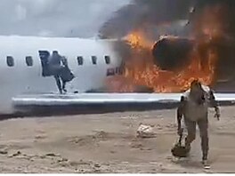 Cestující prchající z hoícího letadla, bhem evakuace. (17. listopadu 2025)