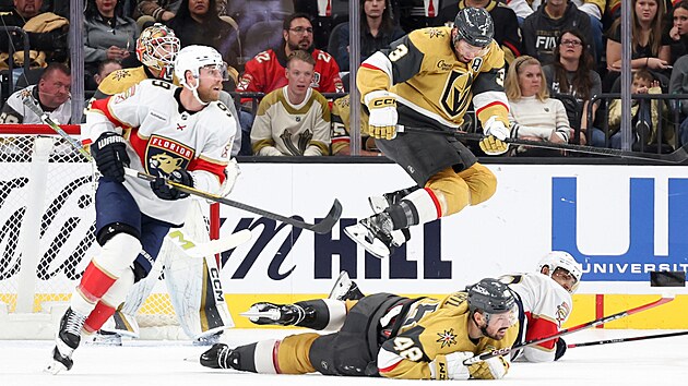 Obr�nce Golden Knights Brayden McNabb p�eskakuje spoluhr��e Tom�e Hertla.