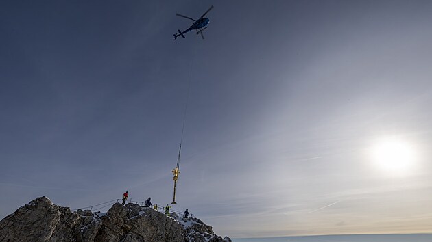 Vrtuln�k sund�v� pozlacen� vrcholov� k�� z nejvy��� n�meck� hory, alpsk�ho vrcholku Zugspitze. (11. listopadu 2025)