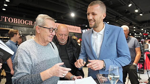 Tom� Sou�ek podepisuje svou autobiografii b�hem k�tu.