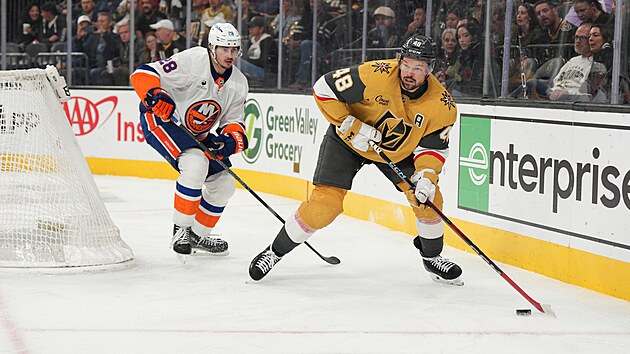 Tom� Hertl (48) z Vegas Golden Knights u puku za br�nou New York Islanders, hl�d� ho Alexander Romanov (28).