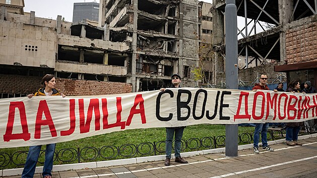 Tis�ce lid� ve st�edu v B�lehrad� symbolicky vytvo�ily lidsk� �t�t kolem komplexu budov b�val�ho gener�ln�ho �t�bu vybombardovan�ho b�hem n�let� NATO v roce 1999. (12. listopadu 2025)