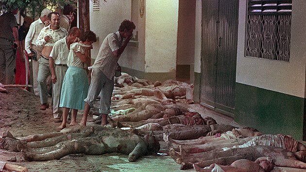 Obyvatel� kolumbijsk�ho m�sta Armero se zacpan�mi nosy hledaj� mezi mrtv�mi sv� p��buzn�. (15. listopadu 1985)