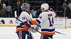 David Rittich (vlevo) a Bo Horvat oslavují výhru NY Islanders nad Utahem.