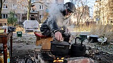 Obyvatel Kos�antynivky p�ipravuje jídlo nad ohn�m poblí� svého bytového domu...