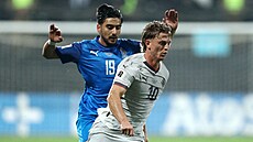 Islandský úto�ník Albert Gudmundsson prchá s mí�em p�ed Chajalem Alijevem z...