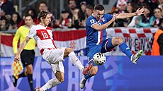 Chorvatský zálo�ník Luka Modri� (vlevo) rozehrává akci v utkání s Faerskými...