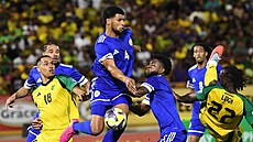 Roshon Van Eijma z Curacaa nejvýe v zápase s Jamajkou, bojují s ním Gregory...