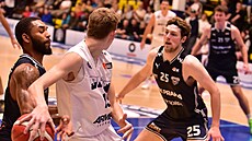 Marek Houka v bílém dresu Dína, v zápase s USK Praha pihrává zadovkou kolem...