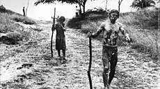 Dva p�e�iv�í jdou s klacky po �pinavé cest� po výbuchu sopky Nevado del Ruíz....