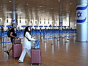 Lidé s kufry v tém prázdné odletové hale mezinárodního letit Ben Gurion...