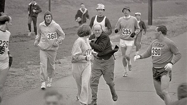 Jock Semple (v civiln�m oble�en�) vstupuje na tra� Bostonsk�ho maratonu a sna�� se zastavit Kathrine Switzerovou (��slo 261). Mu��t� b�ci se kolem n� shlukuj�, dokud organiz�tora neodstr��. (19. dubna 1967)