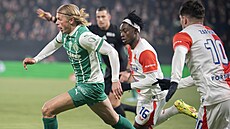 Obránce Vlasij Sinjavskij z Bohemians uniká s mí�em Davidu Mosesovi ze Slavie.