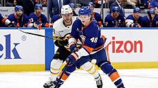 Obránce New York Islanders Matthew Schaefer (v pop�edí) kontroluje puk, napadá...