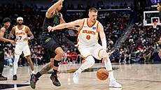 Kristaps Porzingis (vpravo) z Atlanty se sna�í prodrat kolem Micaha Peavyho z...