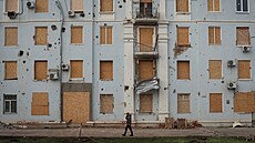 Mu� prochází kolem po�kozené budovy v Kramatorsku (26. listopadu 2025)