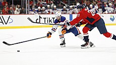 Jake Walman (96) z Edmontonu a Aliaksej Protas z Washingtonu bojují o puk.