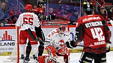 T�inecký branká� Ond�ej Kacetl chytá puk, kdy� se vedle n�j p�etla�ují Marian...