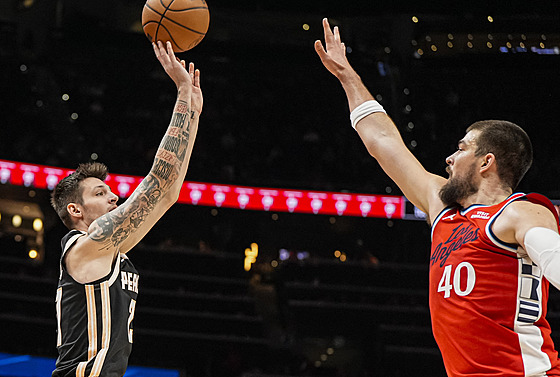 Vít Krej�í z Atlanta Hawks st�ílí na ko� LA Clippers, brání ho Ivica Zubac.