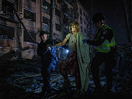 Policisté pomáhají zran�né �en� opustit d�m v Kyjev�, který po�kodil ruský...