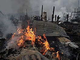 Záchraná�i pracují na míst� skladu, který byl zasa�en b�hem noci ruských...
