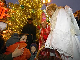 Svatý Mikulá� vp�edve�er svého svátku podle lidové tradice p�iná�í v doprovodu...